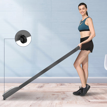 Woman holding a long black object in a room with a light blue wall.