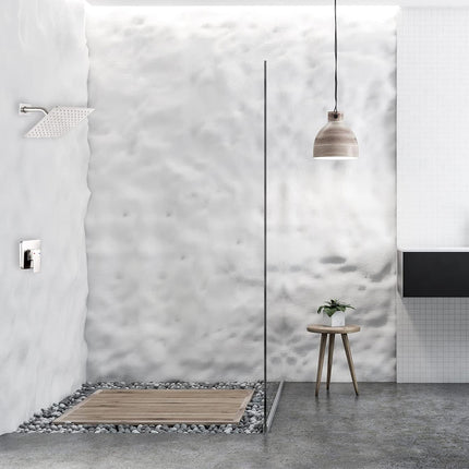 A modern minimalist bathroom interior featuring a walk-in shower area with a textured white wall, a glass screen, a wooden floor mat, a small wooden stool with a potted plant, and a black floating vanity.