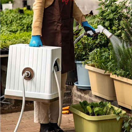 Person watering plants with a portable shower system in a garden setting