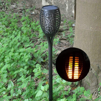 Solar-powered garden light with flame effect on a natural background
