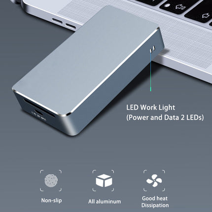 Metallic device with LED work light attached to a laptop on a gray surface