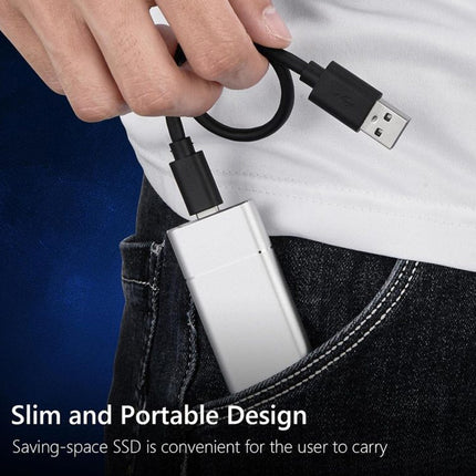 Person holding a slim and portable SSD device with a USB cable.