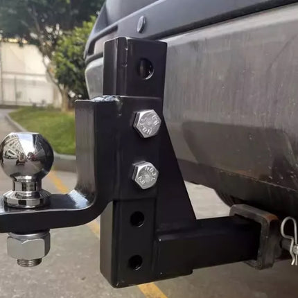 Tow hitch with ball and shank on a vehicle, outdoors.
