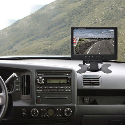 Car dashboard with a mounted monitor displaying a road, surrounded by a mountainous landscape.