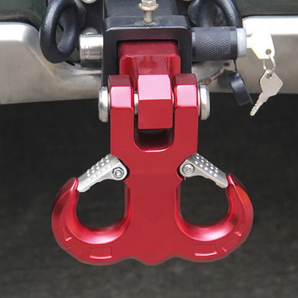 Red carabiner attached to a vehicle's roof rack on a dark background