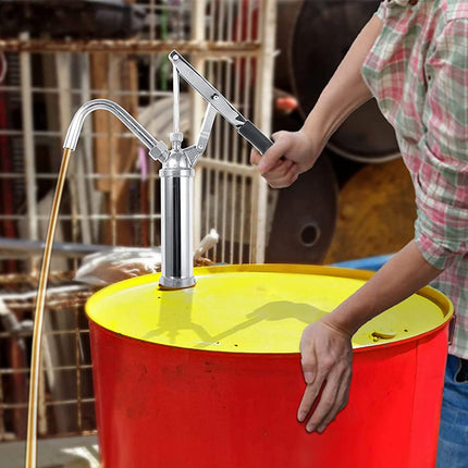 Person using a hand pump on a red and yellow barrel with a blurred background