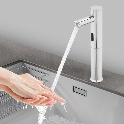 A modern single-handle sink faucet with running water, shown installed on a gray countertop above a sink. A person's hands are visible under the stream, demonstrating use in a real kitchen-like setting.
