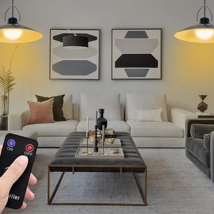 Living room with a hand holding a remote control, indicating smart home technology.