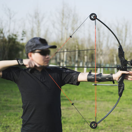 Person using a compound bow in an outdoor setting