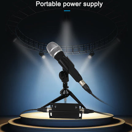 Microphone on a stand with a portable power supply under spotlights on a dark background