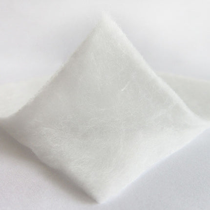 Close-up of a white ceramic plate with a textured surface on a light gray background