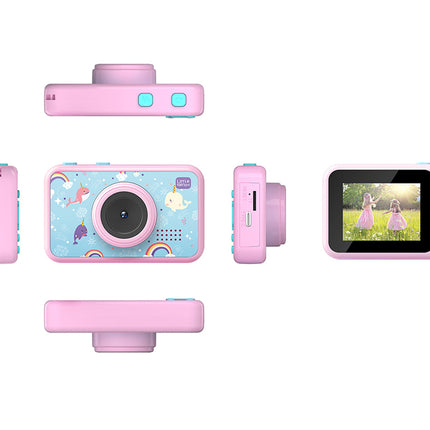 A pink children's digital camera shown from multiple angles on a white background, including front, back, side, and screen views. The front has a pastel blue unicorn-themed print with a rainbow and moon, and the camera body is pink with light blue buttons.