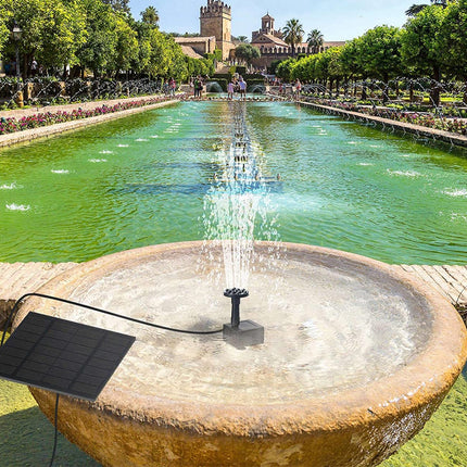 Solar panel powering a fountain in a park with a castle in the background