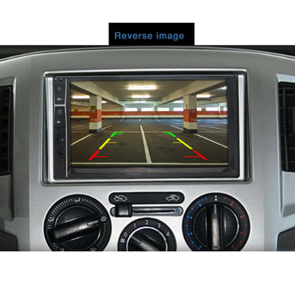 A car dashboard display screen showing a reverse parking garage image with red and green parking guidance lines, mounted in a silver vehicle console with air vents and climate controls.
