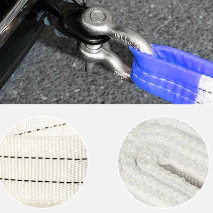 Close-up of a metal clip attached to a blue and white webbing strap on a textured surface.