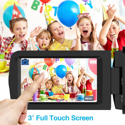 Hand holding a digital photo frame displaying a birthday party scene with children, against a backdrop of colorful balloons and decorations.