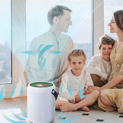 A white cylindrical air purifier with a green inner filter opening sits on a tiled floor in a bright living room, with a family of four overlaid in front of large windows. Blue airflow graphics are visible around the device.