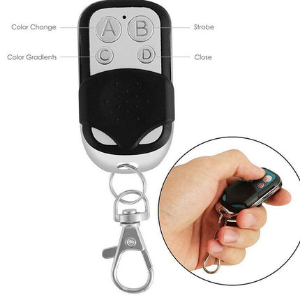 A black and silver remote control keychain with a metal clasp, shown on a white background with a circular inset of a hand holding the remote. The main image includes labeled callouts pointing to buttons and color effects.