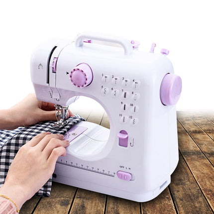 Person using a white and purple sewing machine on a wooden surface