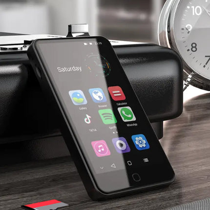 Smartphone with app icons on a stand next to a clock on a wooden surface