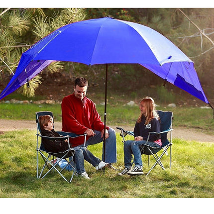 Family sitting under a large blue umbrella in a park setting