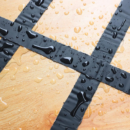 Wet bathroom floor with a black rubber mat