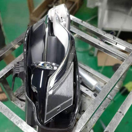 Chrome car headlight on a metal frame with a blurred background