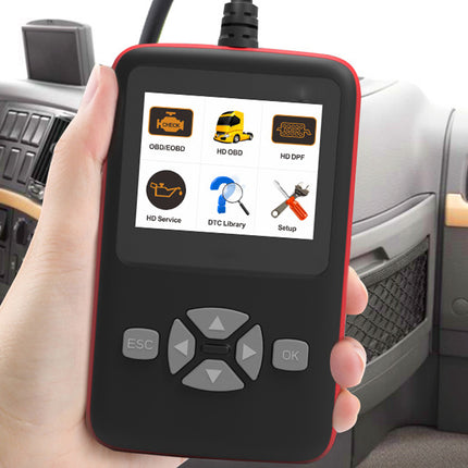 Car diagnostic tool held in a hand with a car interior background