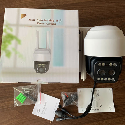 Mini auto-tracking WiFi dome camera with packaging and accessories on a wooden surface