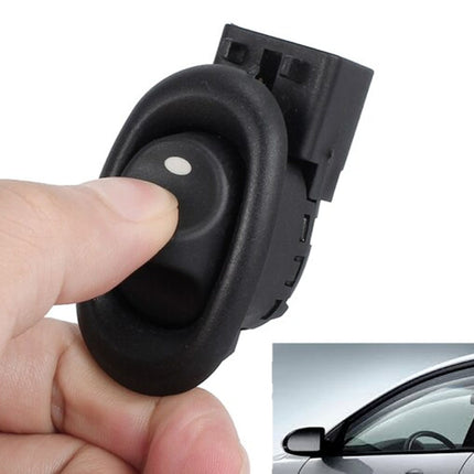 Car door handle actuator held by a hand with a car in the background