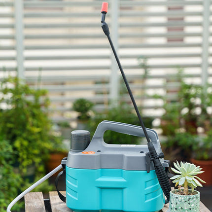 A portable electric pressure washer with a turquoise and gray body, a long black wand with a red spray nozzle, and a white hose, set on a wooden table in a garden environment with a small potted succulent.