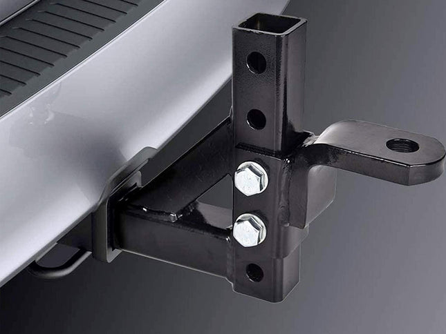 Close-up of a black metal hitch receiver mount attached to a silver vehicle body, with two silver bolts visible against a dark gray background.