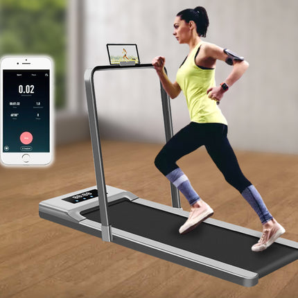 Woman using a portable treadmill with smartphone app interface on a wooden floor.