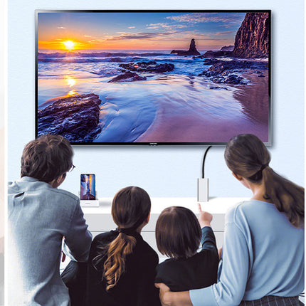 Family watching a scenic display on a large screen TV in a modern living room.