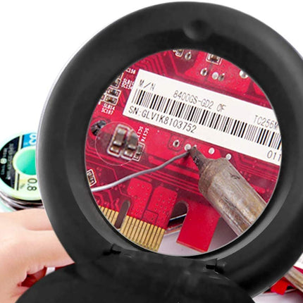 Close-up of a small electronic device with a red circuit board inside, held by a hand.