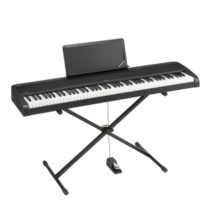 Digital piano with stand and foot pedal on a white background