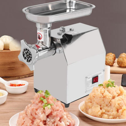 Meat grinder with ground meat and prepared dishes on a wooden table