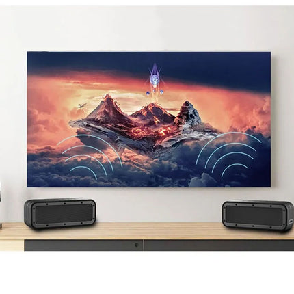 Television displaying a mountain scene with two speakers on a wooden stand.