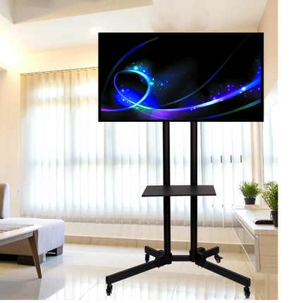 A black TV stand with a wheeled base and a middle shelf, holding a large flat-screen monitor displaying a blue and black abstract graphic. The stand is placed in a bright, modern living room with white curtains and light-colored walls.