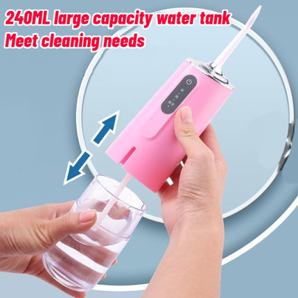 Pink water pump with a 240ML water tank being used to fill a glass, on a light blue background.
