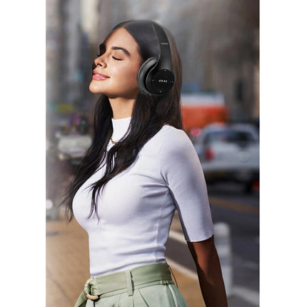 Woman wearing headphones with a blurred street background