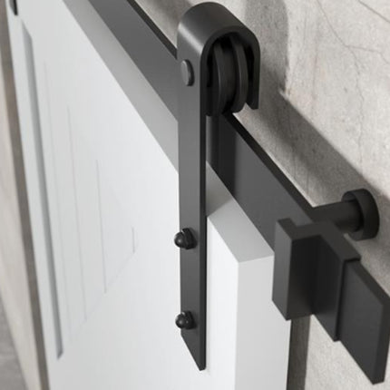 Black sliding door hardware on a white door with a light gray wall background