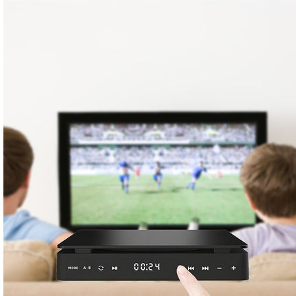 Two children watching a soccer match on a television with a remote control in front.