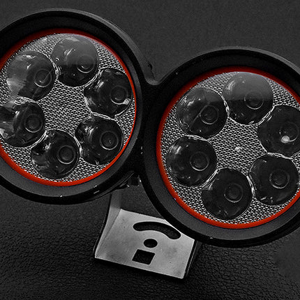 Close-up of a vehicle's headlight with multiple lenses on a dark background