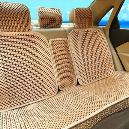 Beige woven mesh car seat covers installed on a vehicle's front seats and backrest, shown inside a car with a blue sky and ocean view visible through the windows.