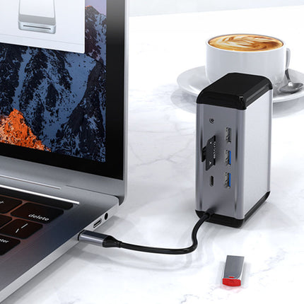 USB hub connected to a laptop on a desk with a cup of coffee in the background
