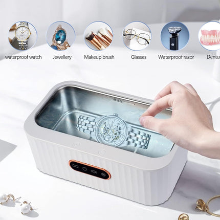 Hand using a small rectangular cleaning device with various items above it on a white background