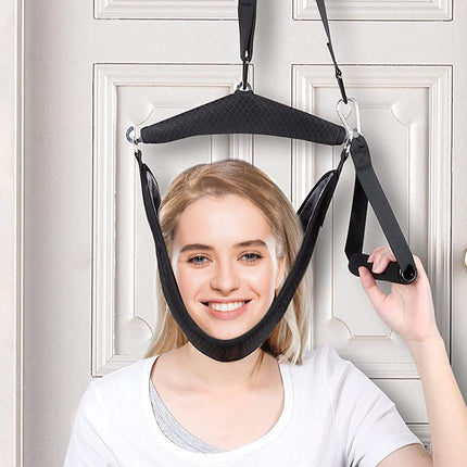 Woman using a black neck traction device against a white door.