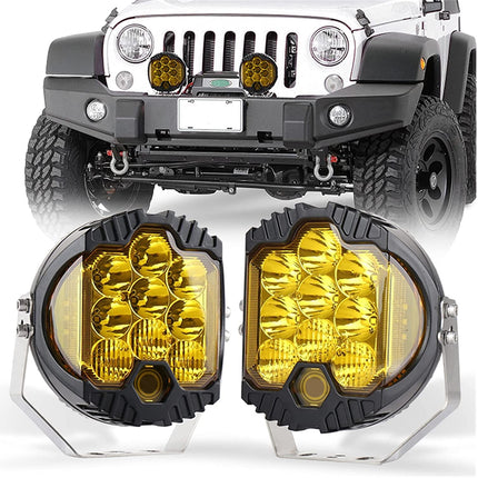 A pair of round auxiliary fog lights with bright yellow lenses and black bezels, shown in front of a white Jeep with the lights installed on the front bumper.