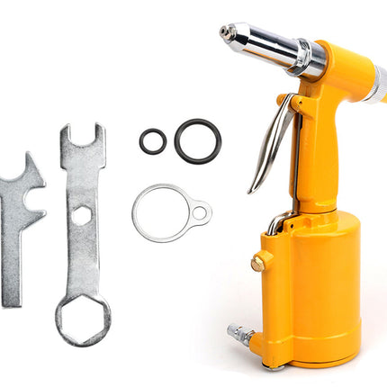 A bright yellow pneumatic rivet gun with a silver metal nozzle and trigger, shown alongside three silver metal driver bits, two black O-rings, and one silver ring-shaped gasket on a plain white background.